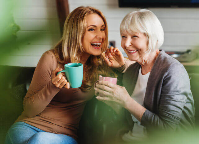 caregiver and elderly woman drinking coffee